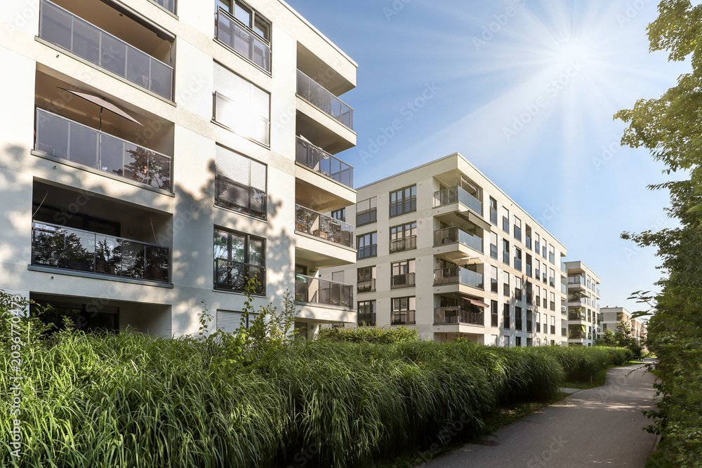 Naklejka premium Cityscape of a residential area with modern apartment buildings, new sustainable development and green urban landscape in the city, concept for construction industry and real estate
