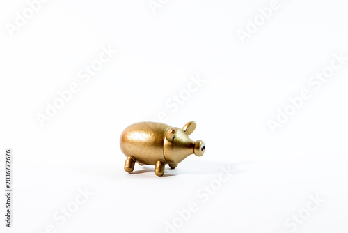 A shiny gold pig figurine symbolizing wealth and prosperity isolated on a clean white background