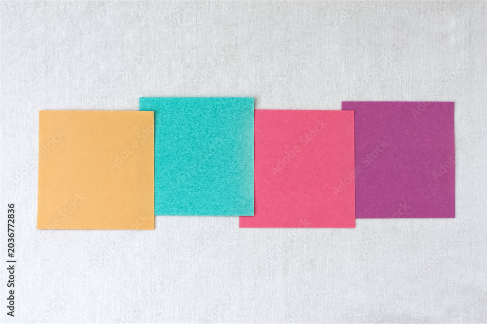 Fototapeta premium Four colorful blank sticky notes in a row on white linen background with copy space, multicolored paper options template.