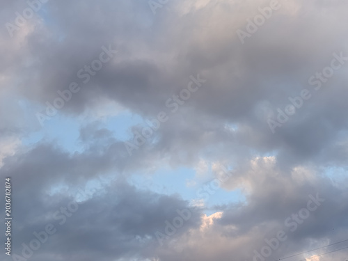 Dramatic Dark Clouds Opening to a Soft Blue Sky at Dusk for Atmospheric Nature Backgrounds