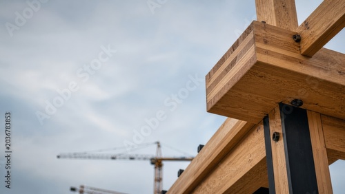 Heavy engineered mass timber beams in realistic architectural style with blurry construction crane background for sustainable mass timber construction marketing presentation template
