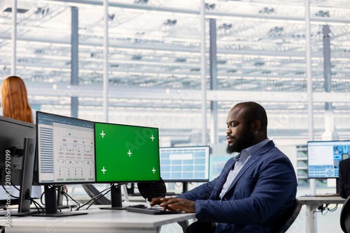 Tableau sur toile Green screen computer used by African American man evaluating PCB system architecture in RD office, Employee looking at EDA program interface on mockup PC, doing microelectronics design automation