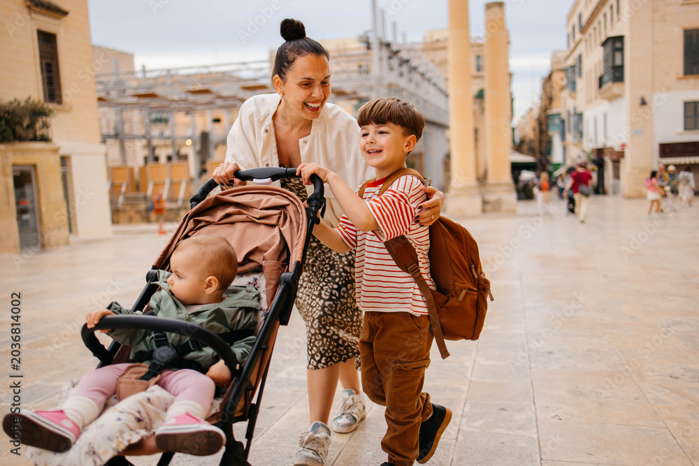 Naklejka premium Mother and two twin kids travelers