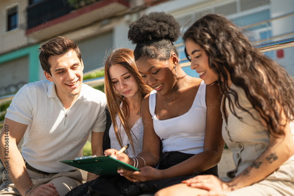 Fototapeta premium Diverse students collaborating on assignment outdoors