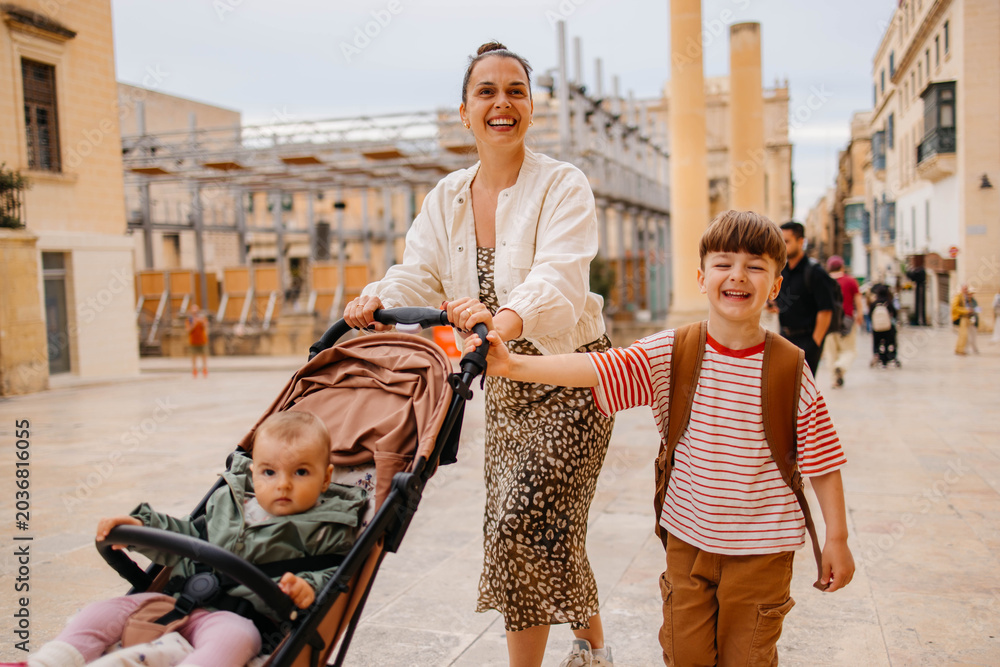 Naklejka premium Mother and two twin kids travelers