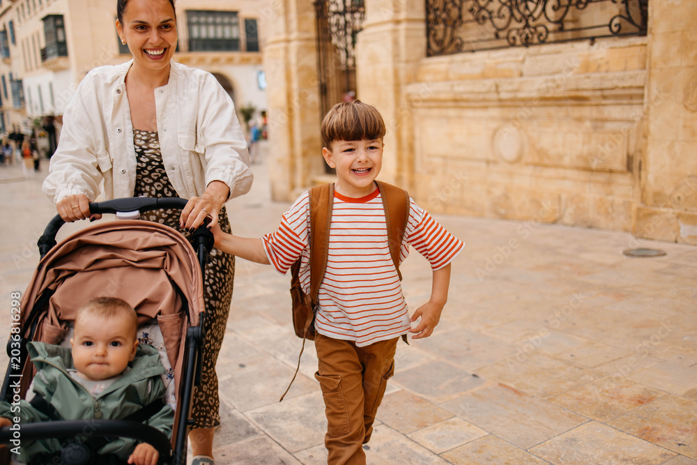 Naklejka premium Mother and two twin kids travelers