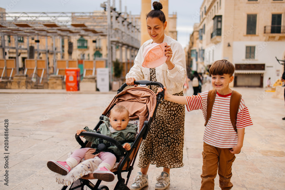 Naklejka premium Mother and two twin kids travelers