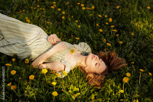 Foto Woman Relaxing in a Field of Dandelions on a Sunny Day