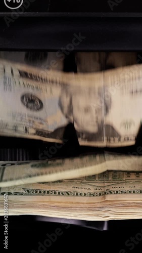 Money counting machine. Currency counting machine counting US money. Slow Motion, vertical video.