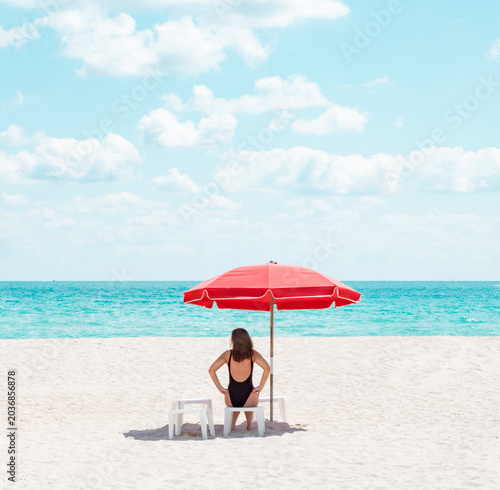 woman under beach umbrella chair miami florida