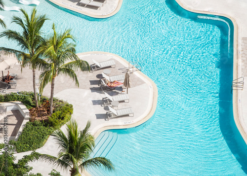 aerial drone woman pool relaxing chair miami florida