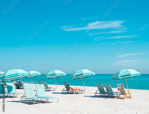 bikini woman on beach chair with colorful umbrellas in miami florida