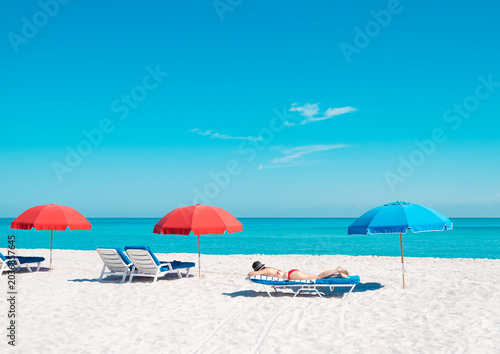 bikini woman on beach chair with colorful umbrellas in miami florida