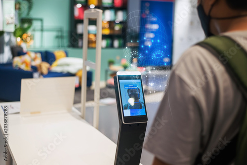 Facial recognition biometric terminal scanning a person for security access.