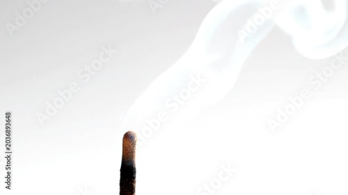 Wisps of fragrant smoke gracefully rise from a burning incense stick, creating a serene and contemplative atmosphere for relaxation and mindful practices