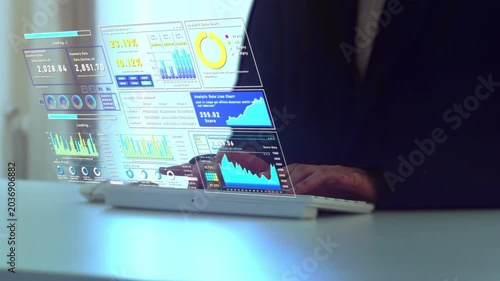 Business employee typing on a keyboard while interacting with a futuristic hologram dashboard displaying analytics charts, financial metrics, and real-time business intelligence for digital transforma