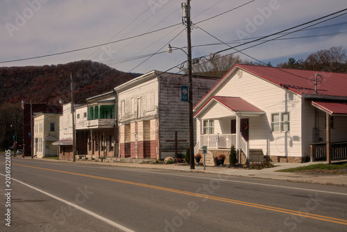 Tableau sur toile Asphalt road passing by wooden buildings and utility lines