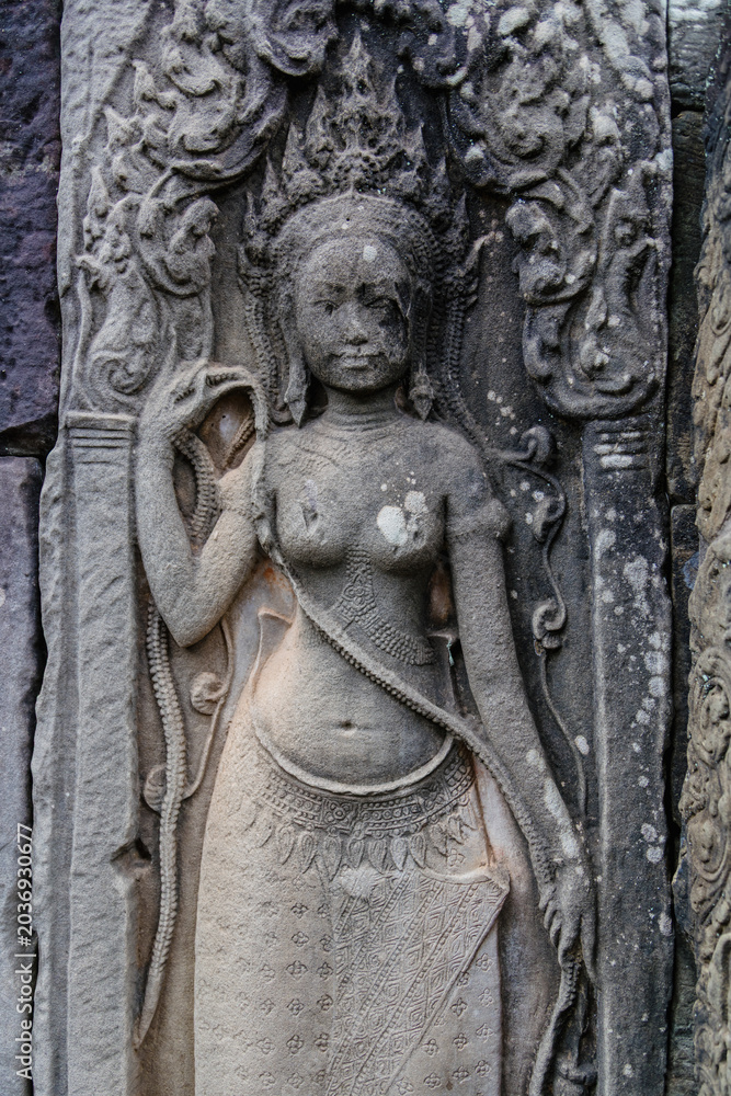 Fototapeta premium Apsara dancer carved into stone at Angkor Wat, Bayon Temple, Siem Reap, Cambodia. These celestial dancers are a common motif in Khmer art and architecture.