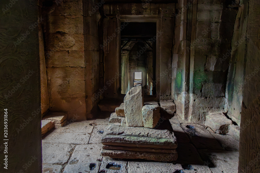 Fototapeta premium Ancient stone altar inside a temple ruin in Bayon Temple, Siem Reap, Cambodia. The weathered structure evokes a sense of history and mystery.