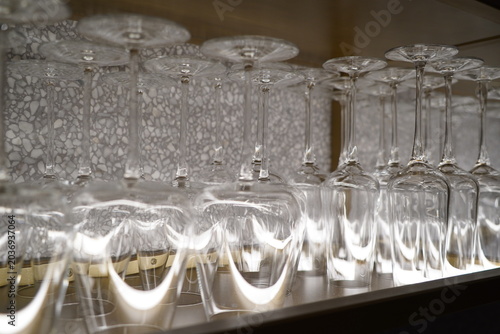 Rows of drinking glasses on a shelf in a restaurant