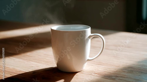 Steaming white mug on wooden table in cozy setting