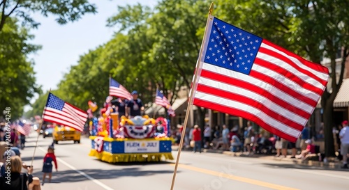 American flag on stick in foreground, parade float and people in background.