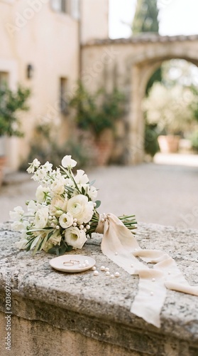 Bridal Bouquet with Wedding Rings on Stone Wall in European Villa