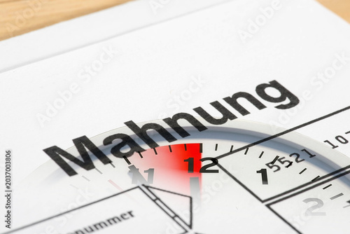 Ein Mahnung und eine Uhr 5 vor 12 als Symbol für den Zeitdruck und Streß wegen unbezahlter Rechnungen	