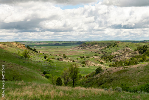 Bild auf Leinwand Prairie and bluffs provide a scenic view under a cloudy sky in Theodore Roosevelt National Park in North Dakota