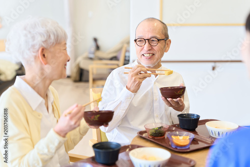 Фотография 介護施設で話をしながら食事をするシニア