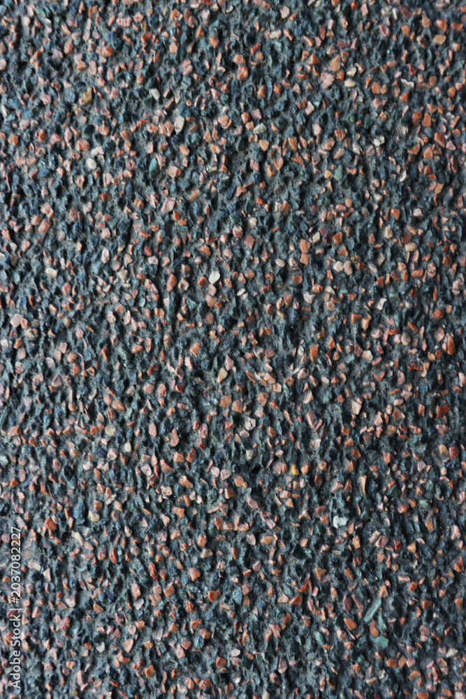 Fototapeta premium A black and brown stone wall with a lot of small rocks on it
