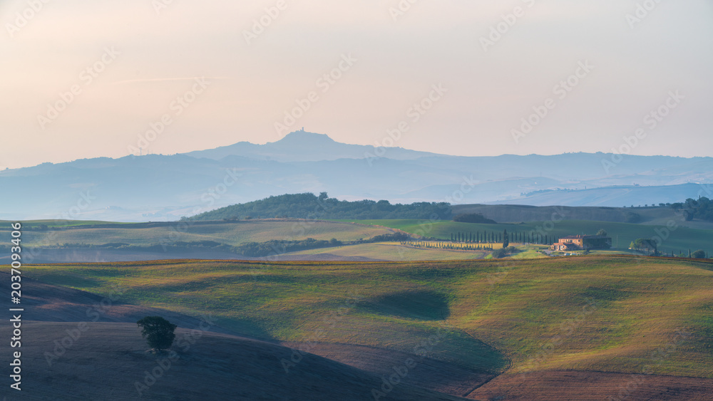 Obraz premium Beautiful sunrise landscape of Tuscany rolling hills with morning fog and distant mountains, Italy