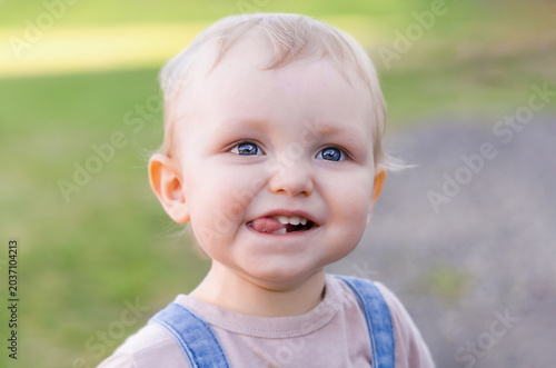 Portrait of a cute toddler laughing and showing tongue.