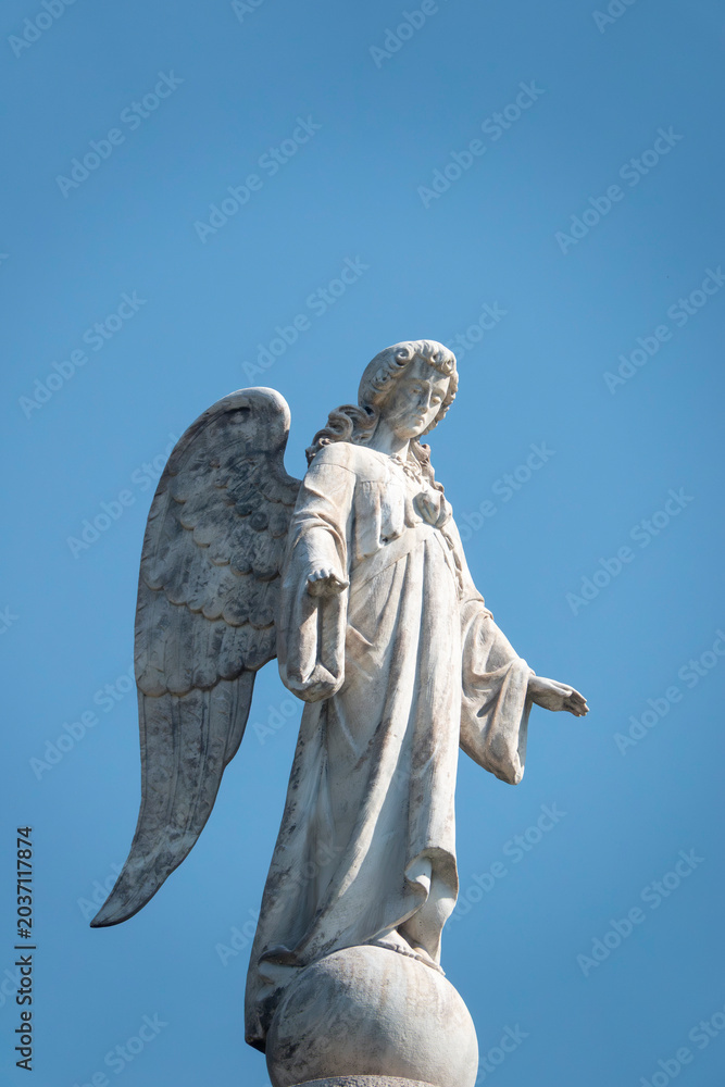 Obraz premium Statue of an Angel at the top of tower.