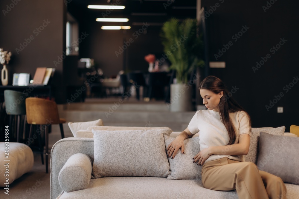 Obraz premium Woman relaxing on couch in furniture showroom