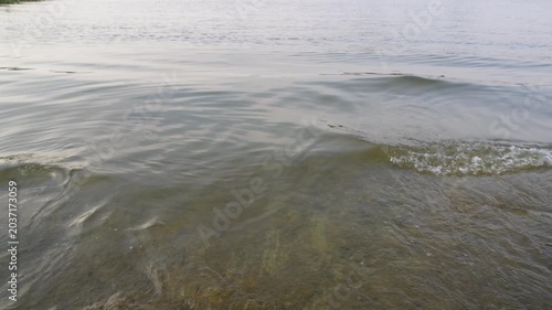 Small waves moving across calm lake surface video