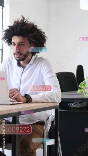 Vertical video: Man typing at laptop in business while UI badges moving, reacting with glance