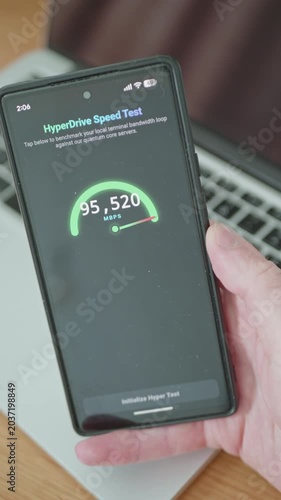 Hand holding smartphone displaying futuristic cellular speed test application UI