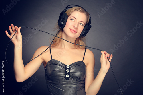 Young woman listening to music on headphones smiling