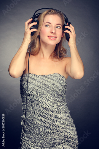 Young woman listening to music on headphones smiling