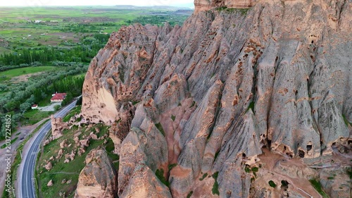 aerial massive steep volcanic cliffs containing Selime Cathedral caves. Historic rock-cut christian monastery structure in Cappadocia, Turkey