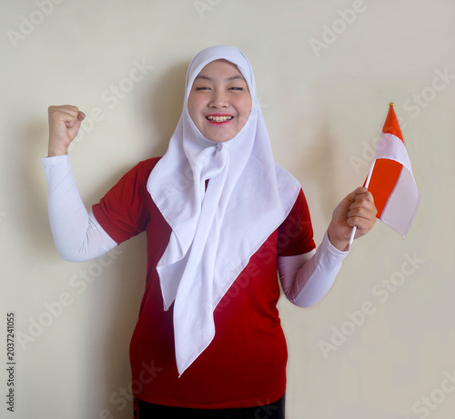 Young Woman Showing Strong Hand Biceps Muscle While Holding National Flag. Football Fans, Sports and Independence Day Concept