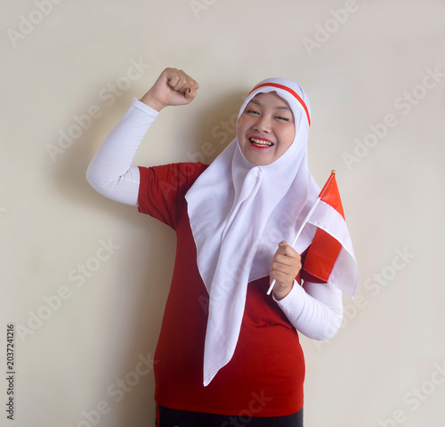 Cheerful Young Girl Raising Fist Celebrating Victory While Holding National Flag. Concept Of Football Fans And Independence Day.