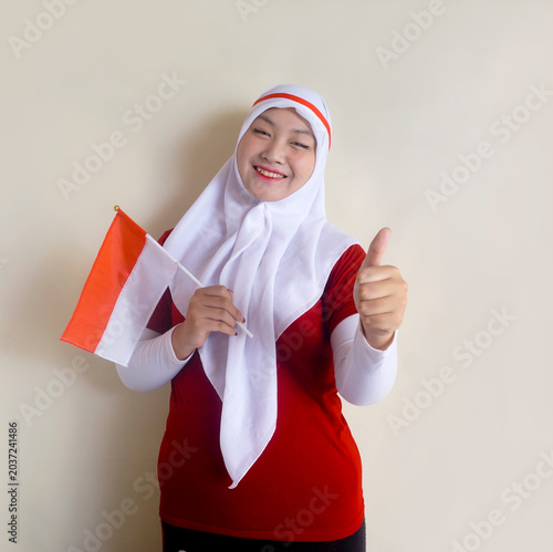 Asian Girl Showing Thumbs Up While Holding National Flag. Concept Of Football Fans, Sports And Indonesia Independence Day Celebration