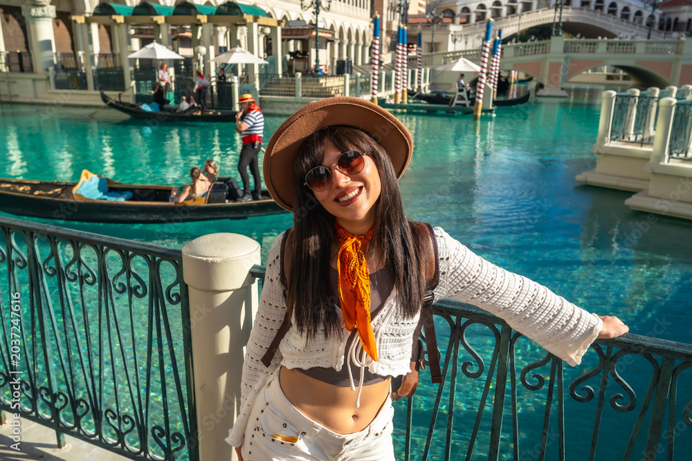 Obraz premium Young woman enjoying las vegas resort architecture and canal