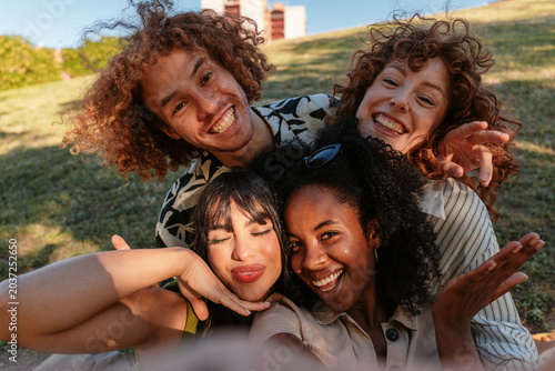 Diverse friends taking selfie smiling outdoors in park