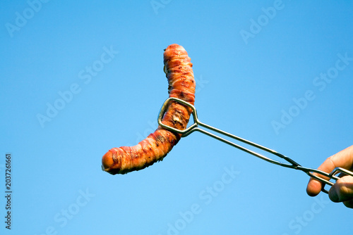 Man holding sausage with gripper