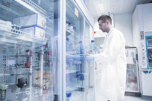 Scientist in microbiological lab opening fridge