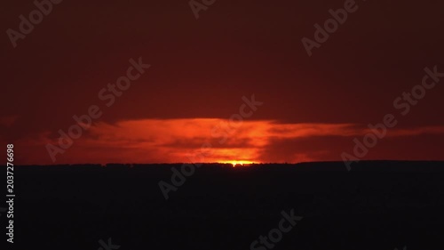 Dark horizon line at red sunset sky with blurred background.