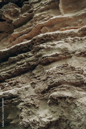 Natural limestone rock texture with layered erosion patterns rough earthy surface abstract geology background organic stone formations desert tones mineral relief and raw nature detail